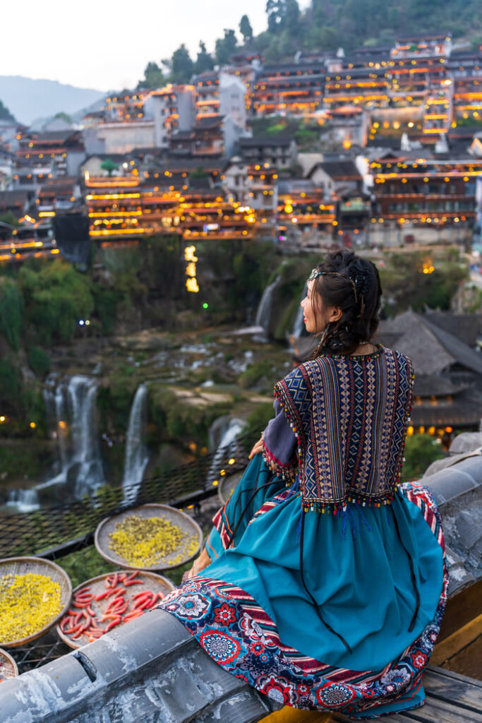 Mujer china y de fondo las luces de la ciudad en china, foto tomada en un viaje personalizado a china