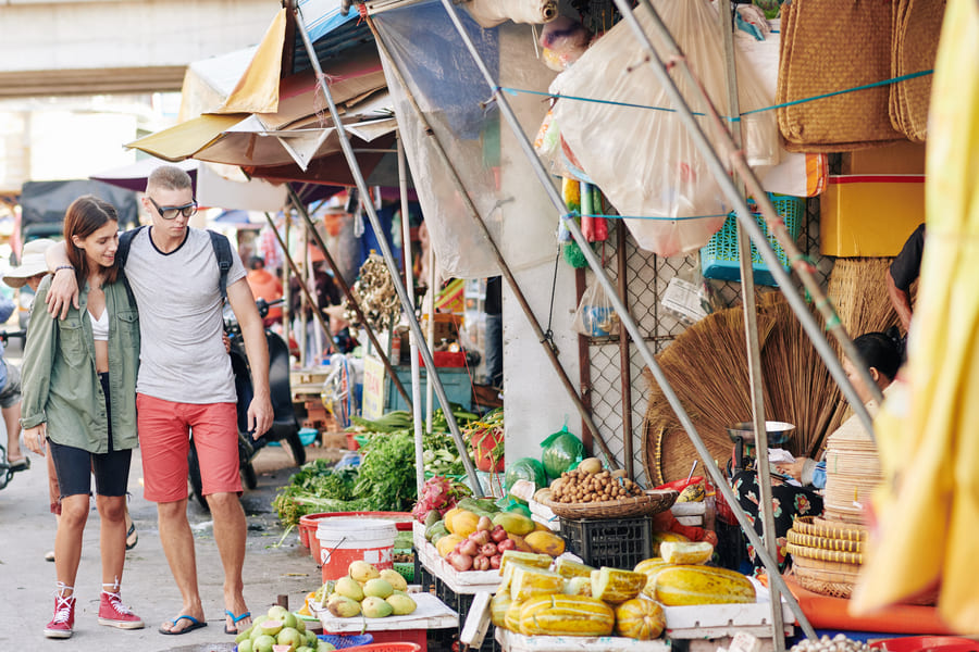 Dos turistas visitando un mercado chino, utilizando su diseño de viaje a China