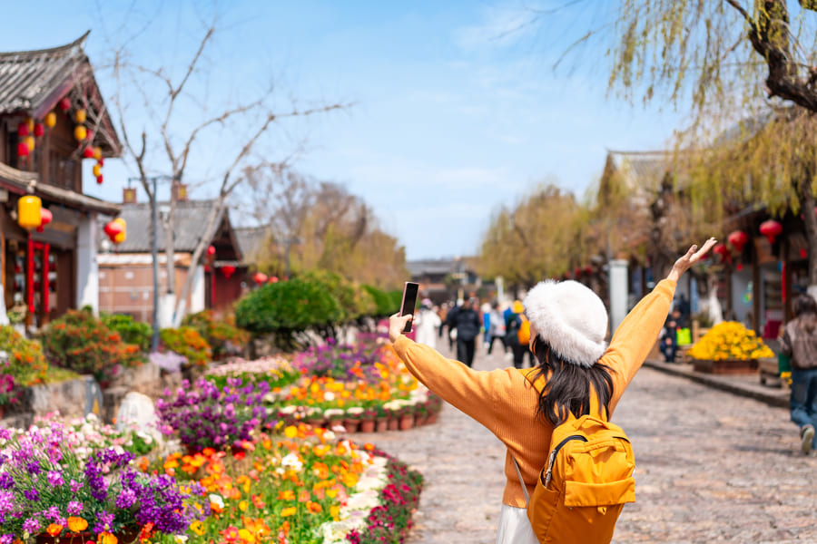 Una chica disfrutando su diseño de viaje a China mientras hace turismo en lijiang