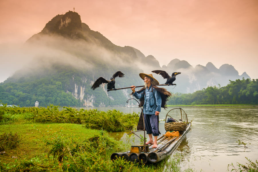 un habitante de yangshuo sobre una balsa en el lago